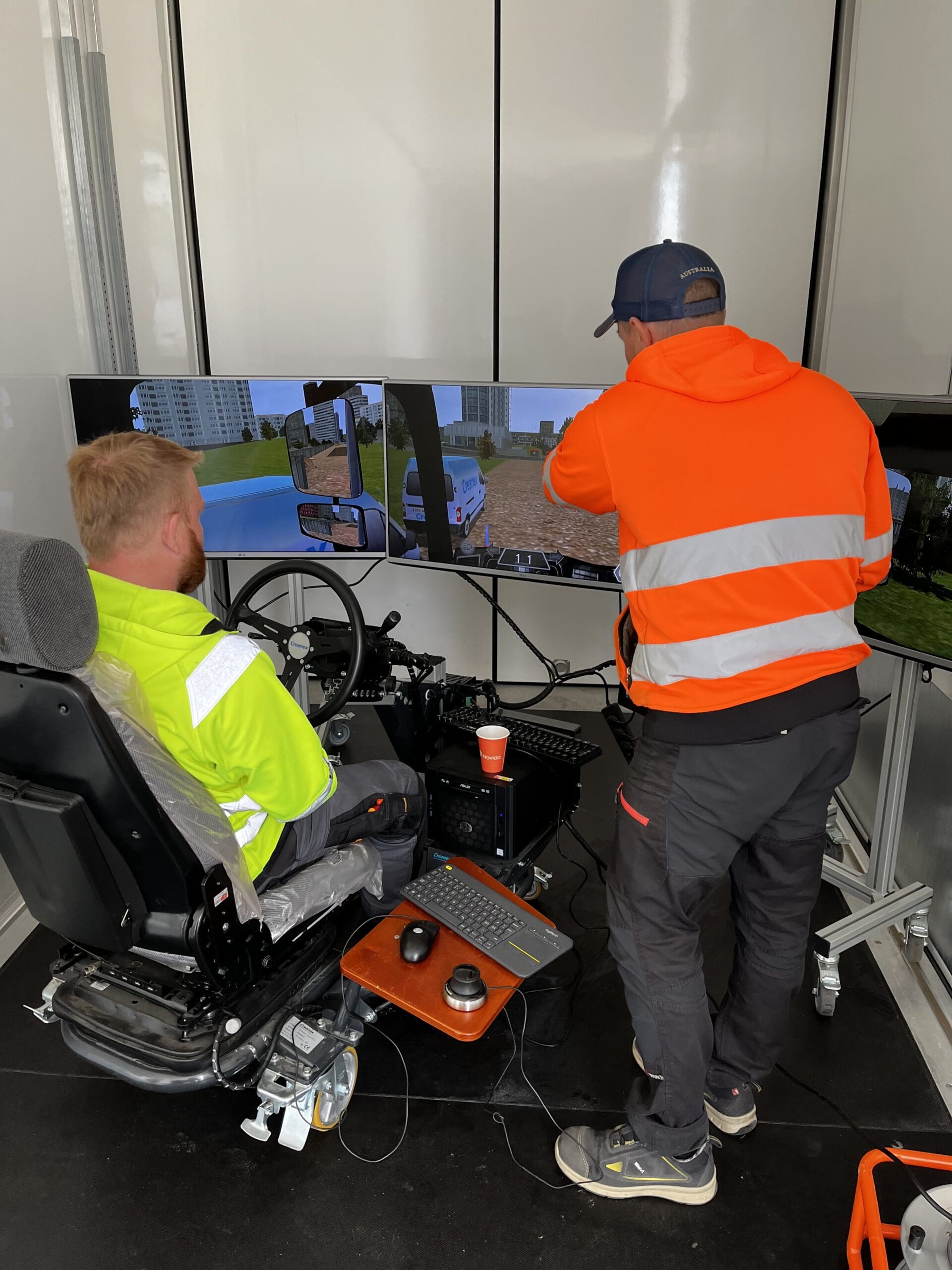 valokuva ajosimulaattorin testaamisesta, jossa kaksi henkilöä harjoittelee simulaattorilla ajoa